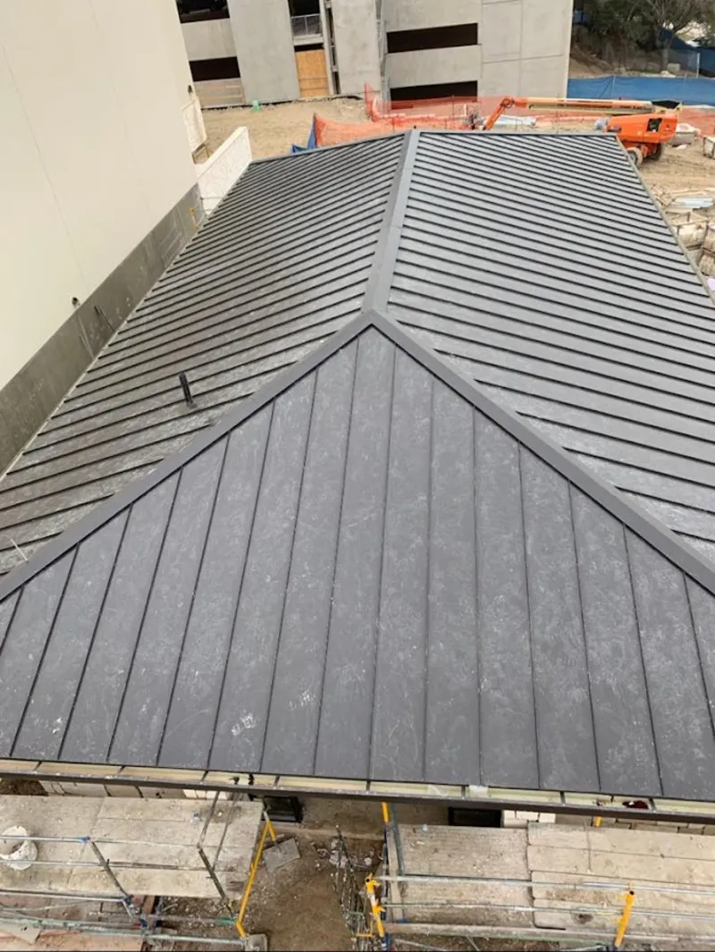 Commercial metal roof construction with crane equipment in Batavia